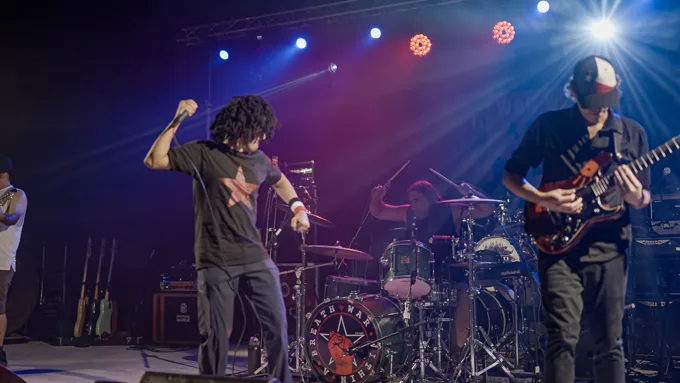 Vocalist and guitarist in front of the drums